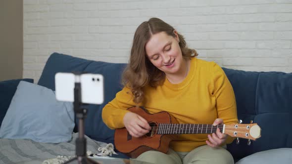 Woman Learns to Play the Ukulele By Watching Video Tutorial on Phone