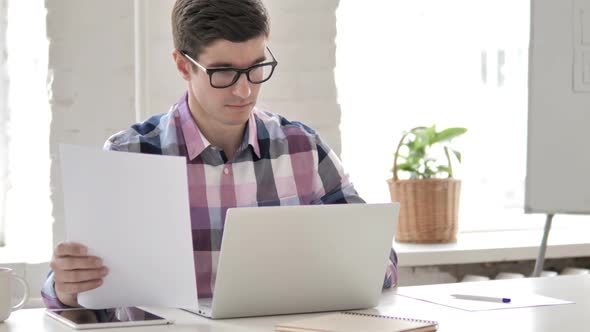 Paperwork Young Man Working on Documents and Laptop