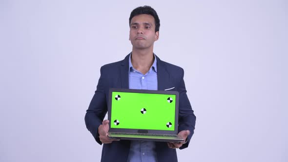 Happy Young Indian Businessman Thinking While Showing Laptop