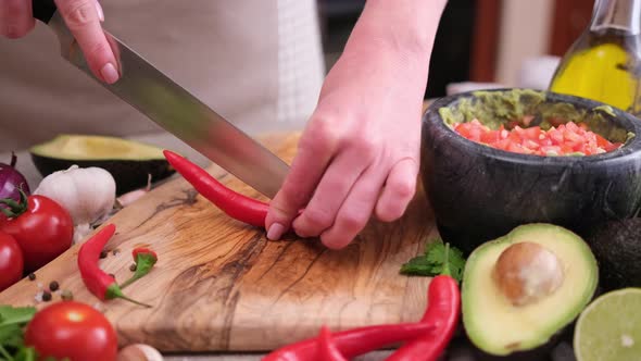 Making Guacamole Sauce  Woman Slicing Chili Pepper on a Wooden Cutting Board