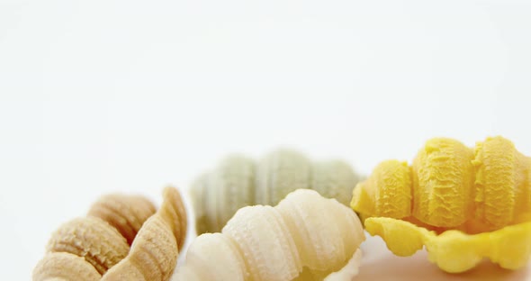 Various conchiglie pasta on white background