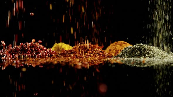 Herbs and spices falling on black surface 4k