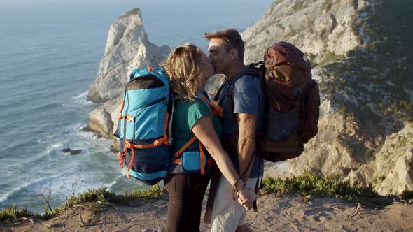 Couple of Excited Backpackers Standing at Cliff