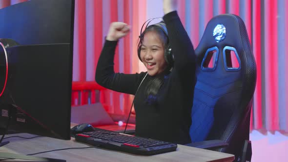 Gamer Kid Girl With Headphones Winner Plays Video Game On A Computer