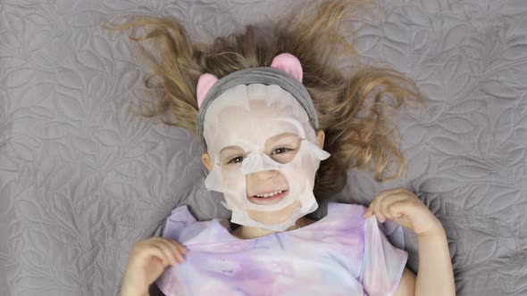 Teen Girl with Moisturizing Face Mask. Child Kid Take Care of Skin with Cosmetic Facial Mask
