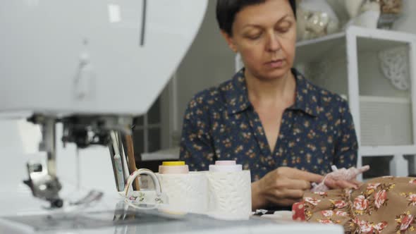Woman working near a sewing machine alt