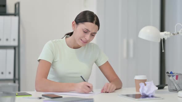 Frustrated Young Latin Woman Failing to Write on Paper