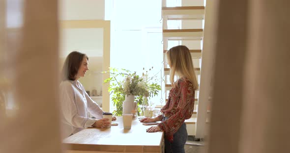 Trendy Millennial Women Talking In Showroom Of Modern Fashion Store.