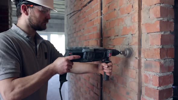 A man builder at a construction site works as a performer.