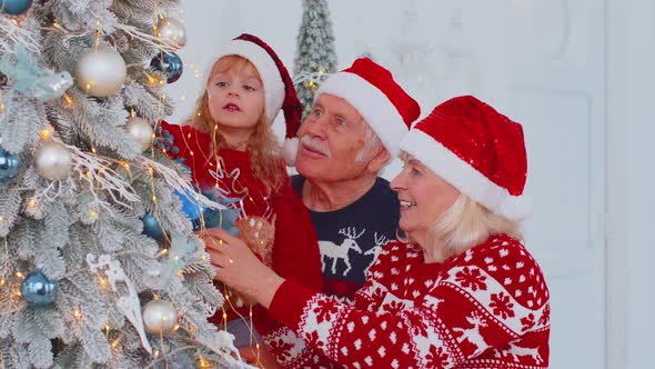 Happy Old Grandparents Granddaughter Toddler Kid Hanging Toys Decorating Christmas Tree Celebrating