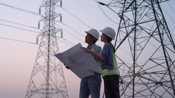 Two specialist electrical engineer working near to High voltage tower