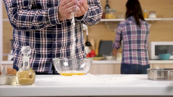 Man Hands Pouring Flour in a Bowl with Eggs