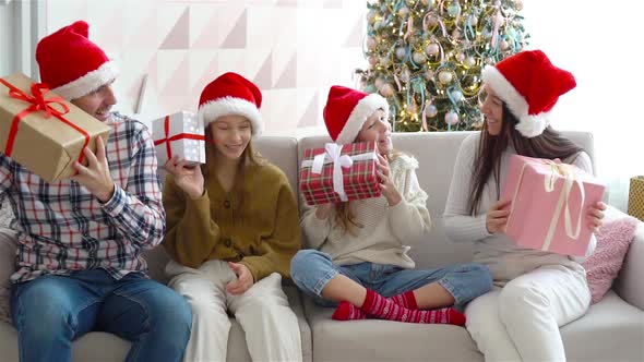 Happy Young Family with Kids Holding Christmas Presents