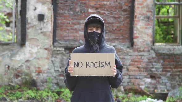 Young Female Protestor Holding Cardboard With Sign No Racism