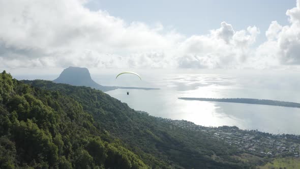 Aerial view of a person doing paragliding among the mountain, Mauritius.