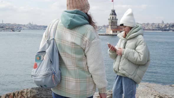 Girl with Smartphone Standing on Seashore and Talking to Mother