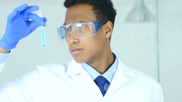 Doctor Looking at Blue Solution in Test Tube