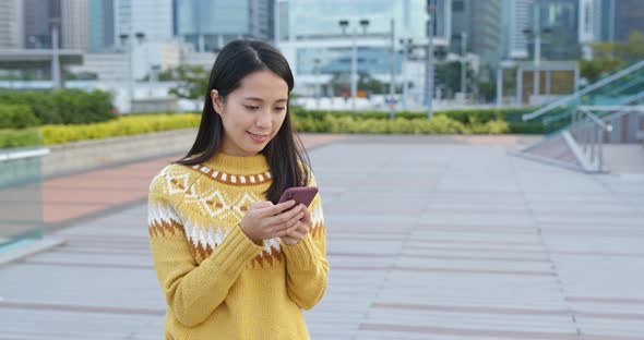 Asian Woman Use of Mobile Phone in City 
