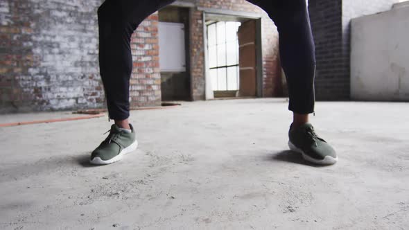 African american man exercising with medicine ball in an empty urban building