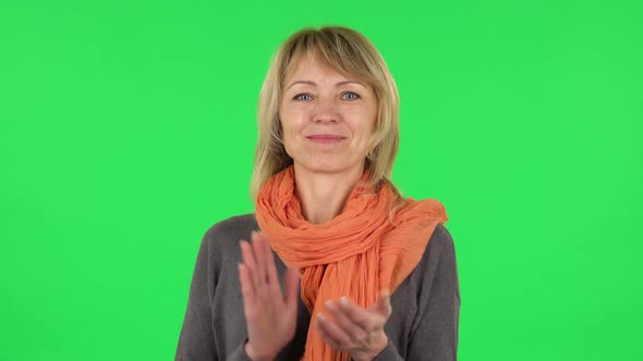 Portrait of Middle Aged Blonde Woman Is Clapping Her Hands. Green Screen