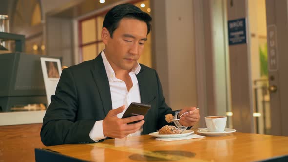 Businessman having food while using mobile phone 4k