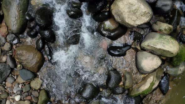 Water is running through the rocks, a background with fresh water and rocks