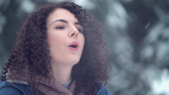 Woman with Afro Curls Blows Steam Through His Mouth in a Winter