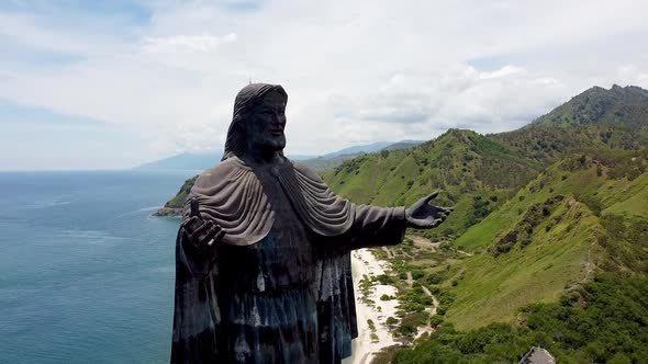 A close up of the Cristo Rei statue of Jesus Christ, aerial drone slowlying away from figure and rev