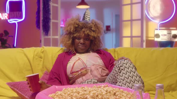 Portrait of Party Girl with Popcorn and Drink on Sofa