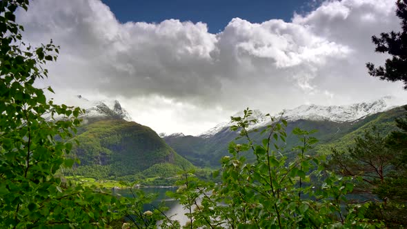 Spring Norway Landscape Background. Mountains, Covered with Green Forest, Snowy Peaks, Fjords