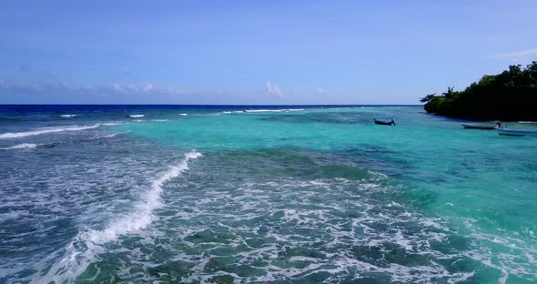 Natural birds eye island view of a white paradise beach and aqua blue water background in vibrant 