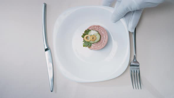 Waiter serving a plate of delicacy