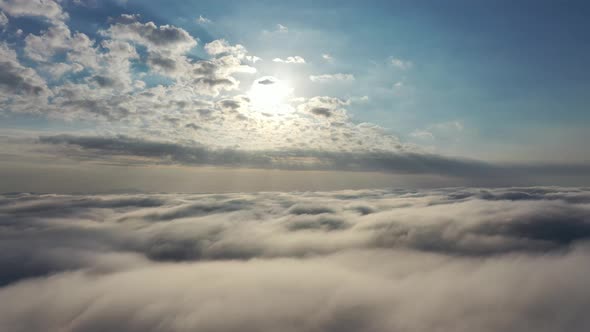 Above the clouds. Sunrise foggy morning.