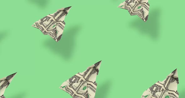 Dollar origami planes fly over green background. 3D Money Paper airplanes - War relation concept