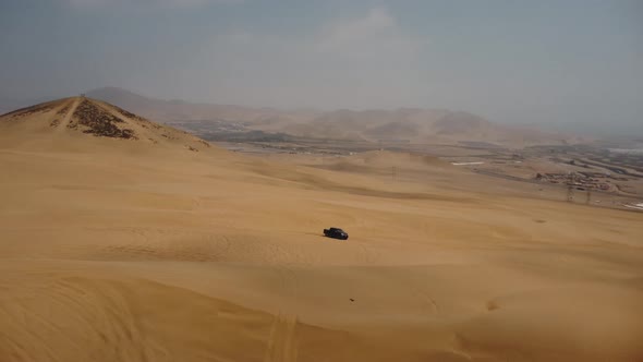 AERIAL - Off-road 4x4 truck tracks in Ica desert sand dunes, Peru, spinning shot