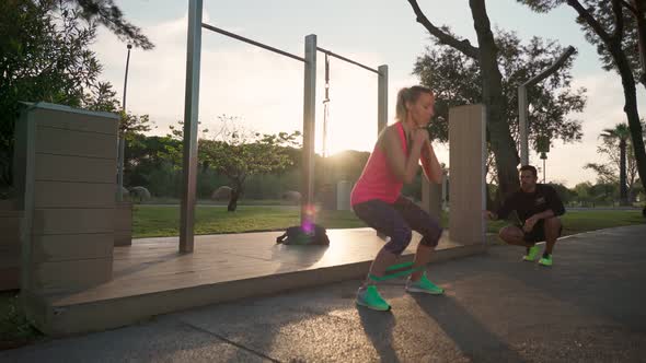 European Woman Training in the Park with a Personal Fitness Trainer