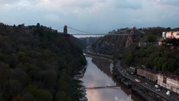 Drone shot along river Avon Hotwell road towards Clifton suspension bridge Bristol at sunset