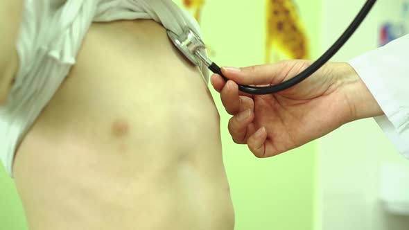 Doctor Examines the Child with a Phonendoscope