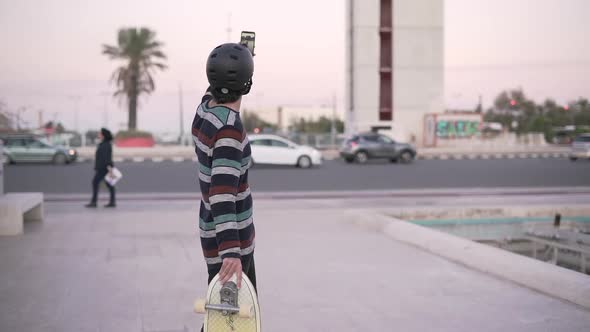 Hipster guy taking selfie with smartphone in city