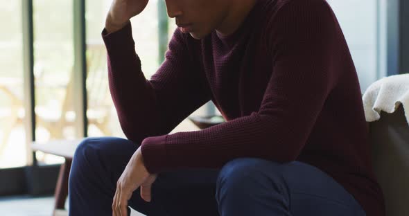 Worried african american man is sitting at home alone