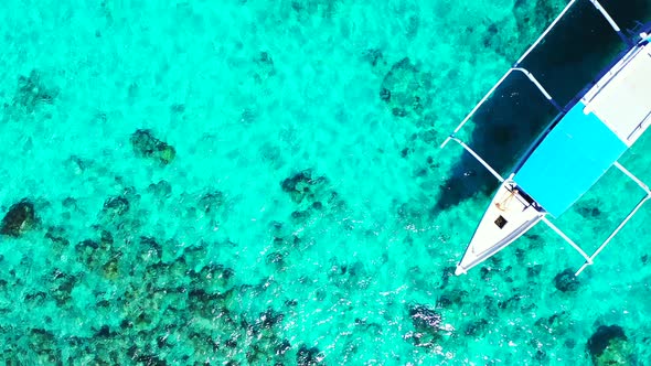 Daytime aerial abstract shot of a white sandy paradise beach and aqua blue ocean background in color