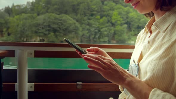 Attractive girl with smartphone on a ship in a national park