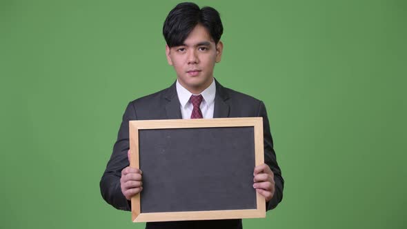 Young Handsome Asian Businessman Showing Blackboard