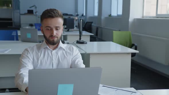 Handsome Bearded Man Sits at His Computer