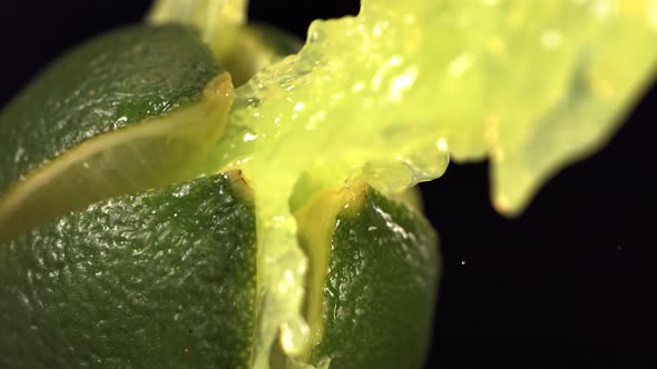 Fresh Lime Fruit Squirting with Juice in Slow Motion in Black Background