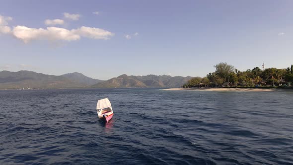 Aerial flyover beautiful indian ocean with anchored ships and empty beach on Gili Air. Corona Virus