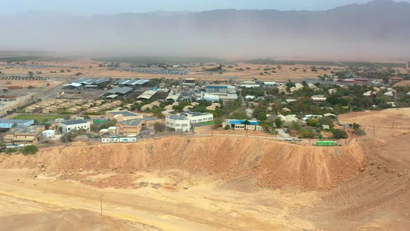 High aerial view of a Negev desert sandstorm behind Kibbutz Yotvata, southern Arava, Israel showing