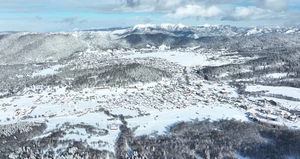 Aerial view of snow covered Bakuriani with beautiful snowy mountains around. Georgia 2021