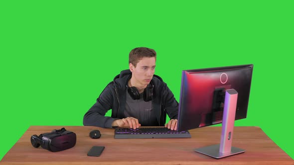 Confident Gamer Looking To Camera with Crossed Hands on a Green Screen Chroma Key