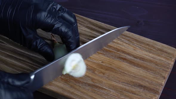 Chef Cuts Fresh Onions with Old Knife Into Pices on Wooden Cutting Board